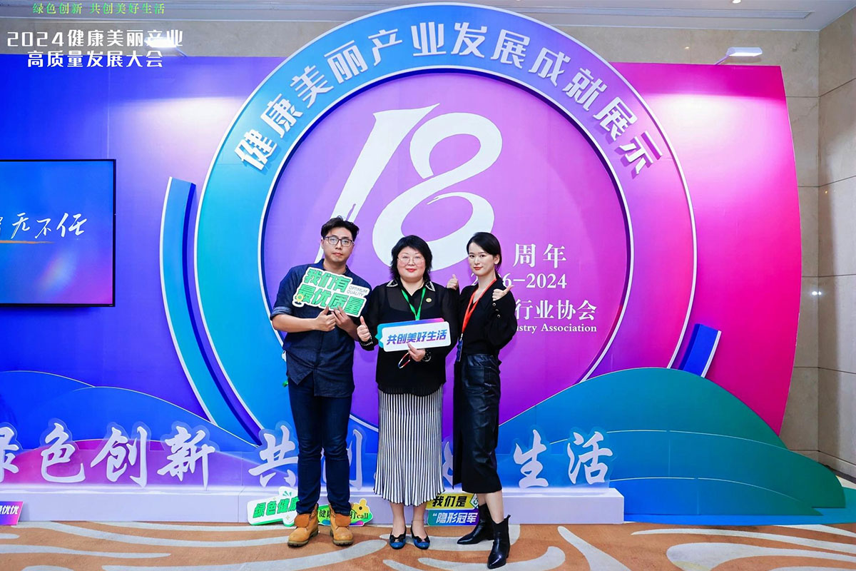大會人員在健康美麗產業(yè)發(fā)展成就展示區(qū)前合影